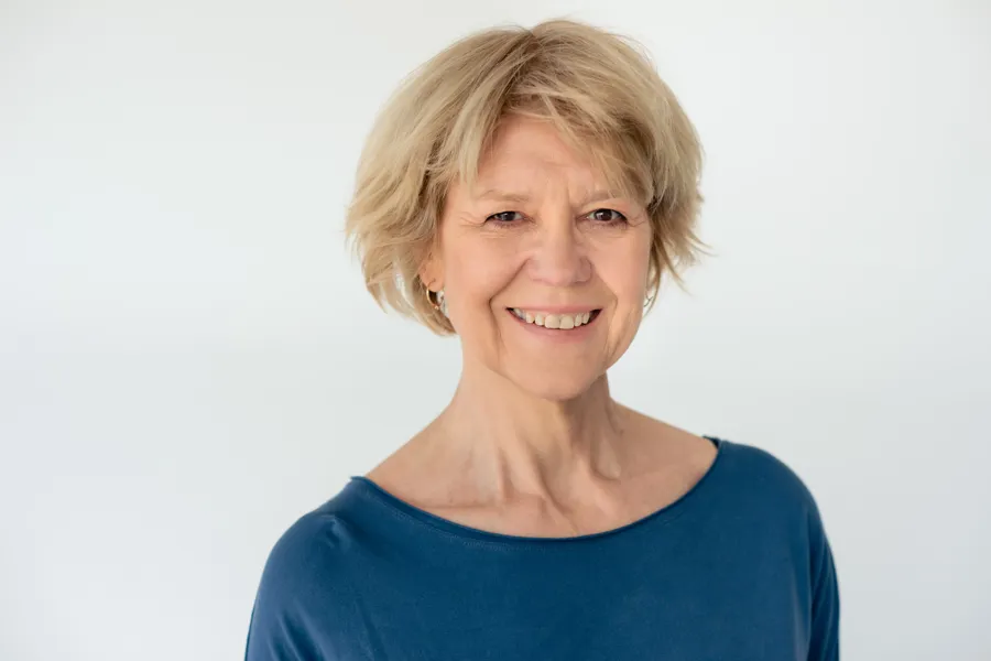En kvinne som smiler til kameraet