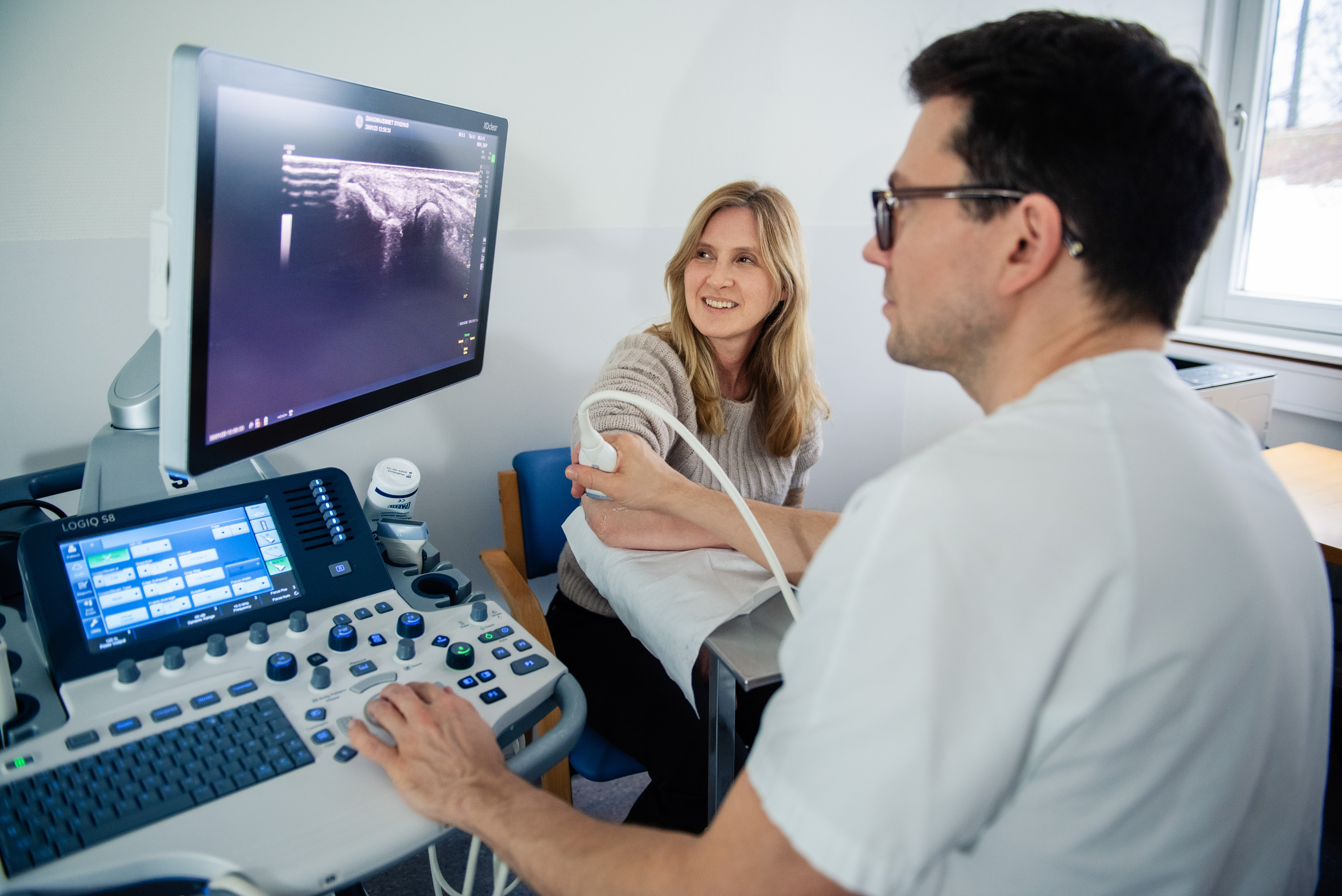 En lege undersøker en kvinnelig pasient