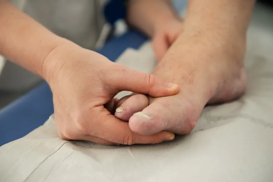hånd som holder i en fot