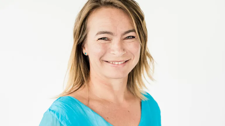 En kvinne som smiler til kameraet