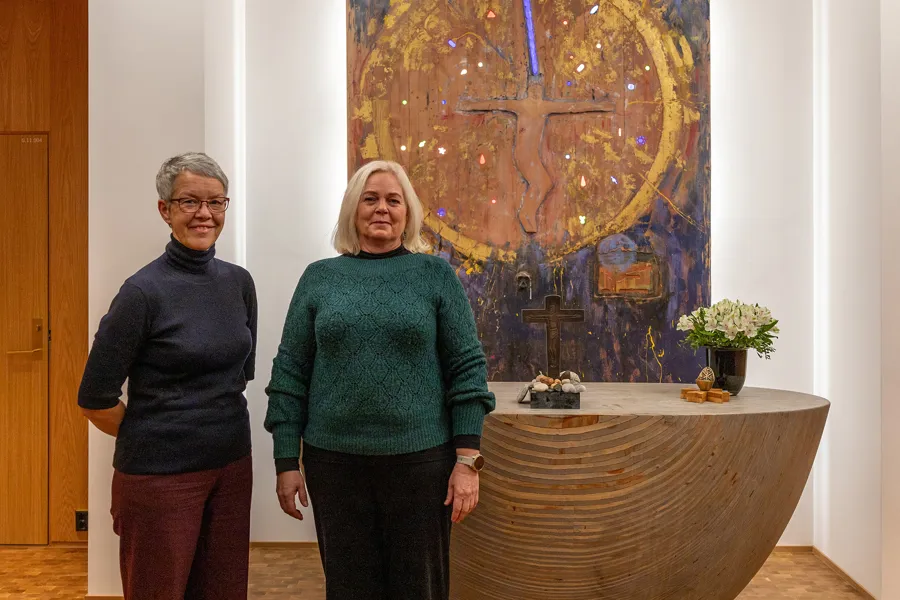Et par kvinner som står foran et maleri
