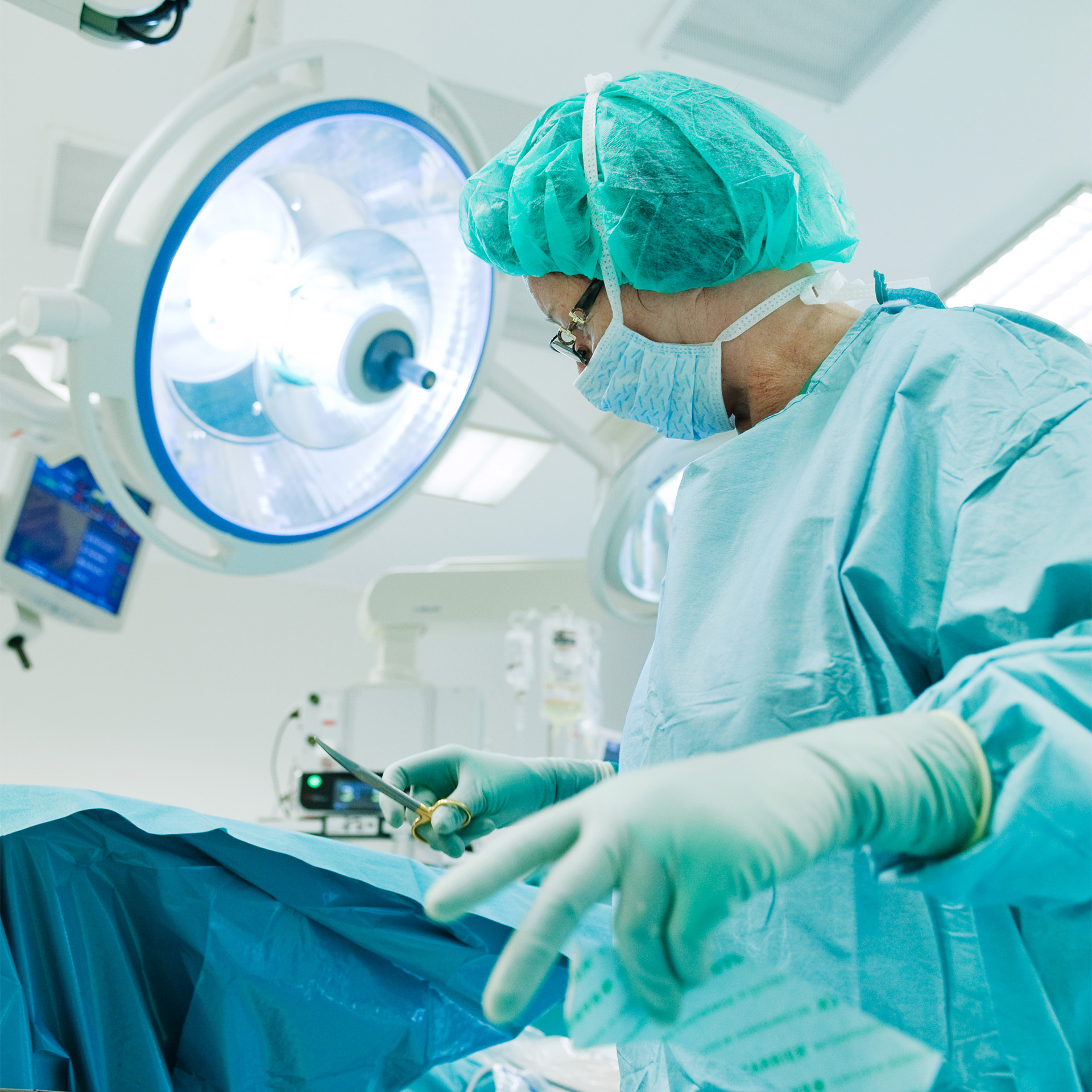 En person i kirurgiske scrubs og en maske i et rom