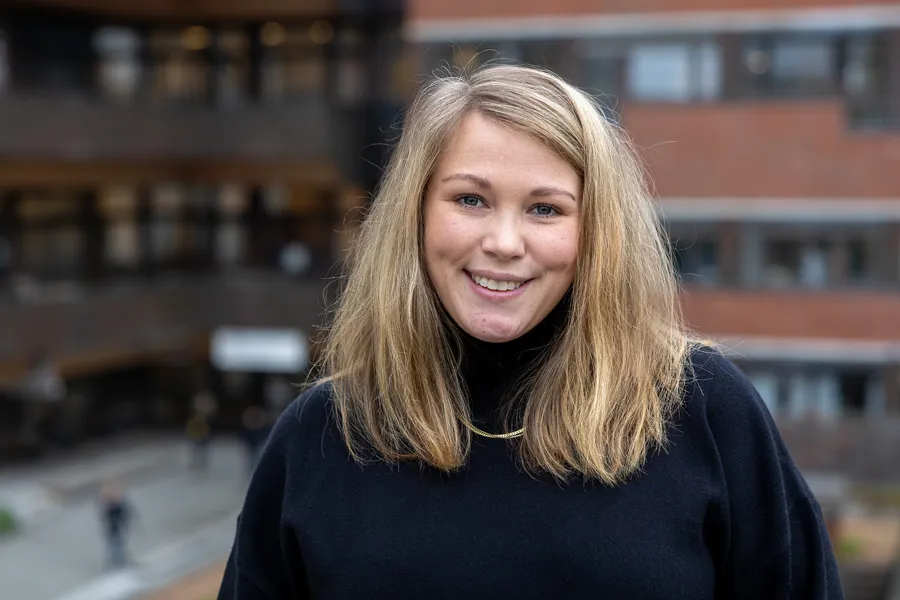 En kvinne som smiler til kameraet