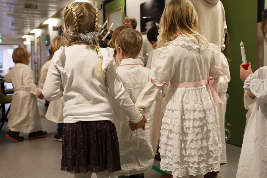 Barn med lys, kroner og i hvite kapper
