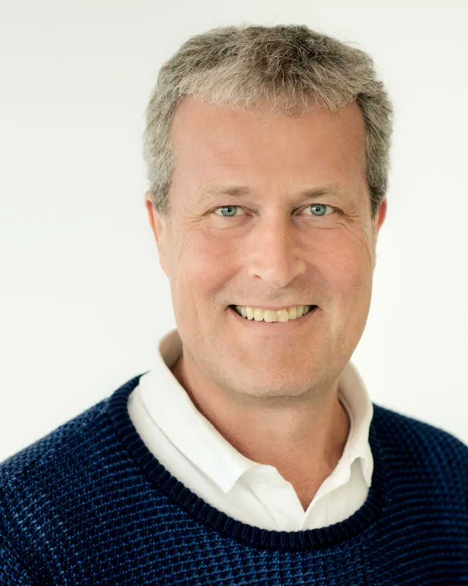 En mann som smiler til kameraet