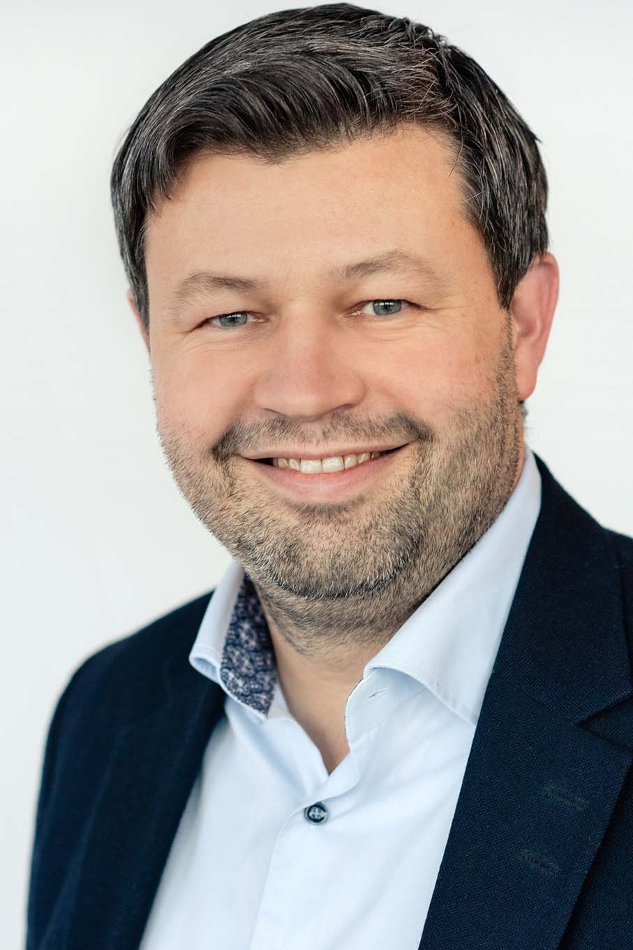 En mann som smiler til kameraet